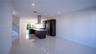 Modern kitchen featuring dark cabinetry, a central island with a stone-finish countertop, recessed lighting, polished tile flooring, and a stainless s