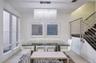 Rectangular crystal chandelier, large-format tile flooring, and a stainless steel horizontal cable railing system