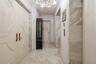 Entryway from a private elevator lobby. Featuring double doors with decorative millwork, stone tile flooring, crown molding, and stone wall accents