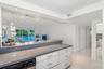 Kitchen featuring a stone countertop, white flat-panel cabinetry, a built-in dishwasher, recessed lighting, and tile flooring