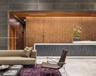 Reception area featuring large-format dark stone wall cladding, vertical wood-slat paneling, stone flooring, and a bespoke reception desk with integra