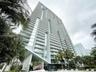 High-rise structure featuring floor-to-ceiling glass paneling, cantilevered architectural design, and private balconies with glass railings