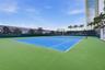 Tennis court with a dual-toned hard surface, perimeter privacy screening, and professional-grade netting