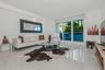 Living area featuring large-format tile flooring, recessed ceiling lighting, and expansive floor-to-ceiling glass sliding doors opening to a balcony