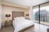 Floor-to-ceiling glass walls, expansive private balcony, stone-finish flooring, and recessed ceiling soffit