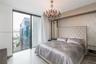 Floor-to-ceiling windows, crystal chandelier, polished stone flooring, and textured wall accent