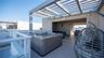 Rooftop terrace featuring a built-in hot tub, slatted metal pergola, tile flooring, and white glass-panel railings