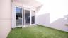 Enclosed patio featuring synthetic turf, high privacy walls, and double-glass entry doors