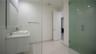 Bathroom featuring a floating vanity with a rectangular vessel sink, wall-mounted mirror, walk-in shower with glass enclosure, and tile flooring