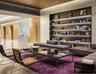 Lobby featuring a wood-panel ceiling, built-in recessed shelving with integrated lighting, polished stone flooring, and flush-mounted wall paneling