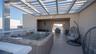 Rooftop terrace featuring a built-in spa, metal-frame pergola, wood-finish decking, and an integrated outdoor kitchen area