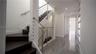 Staircase featuring dark wood-finish treads, a metal tension-cable railing, and a minimalist handrail, complemented by large-format tile flooring and 