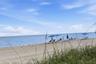 Private sandy beach frontage with native dune grasses and open ocean horizon