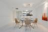 Polished tile flooring, neutral wall finishes, track lighting, and a kitchen pass-through with an integrated breakfast bar