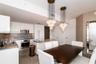 Contemporary kitchen featuring white flat-panel cabinetry, stainless steel appliances, a flush-mount electric cooktop, quartz countertops, and dual mu