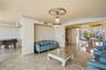 Polished stone flooring, ornate ceiling medallion with a crystal tiered chandelier, multi-pane floor-to-ceiling windows, and recessed ceiling lighting