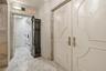 Double entry doors featuring arched molding, stone flooring, and stone wall trim