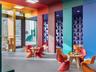 Multicolor interior featuring floor-to-ceiling structural pillars, recessed ceiling lighting, glass door access, and textured wall paneling