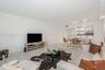 Open floor plan featuring polished tile flooring, recessed lighting, and a kitchen breakfast bar