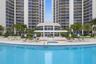 Curved swimming pool with tile trim, integrated spa, poolside bar under a covered canopy, and paved deck featuring mature palm trees