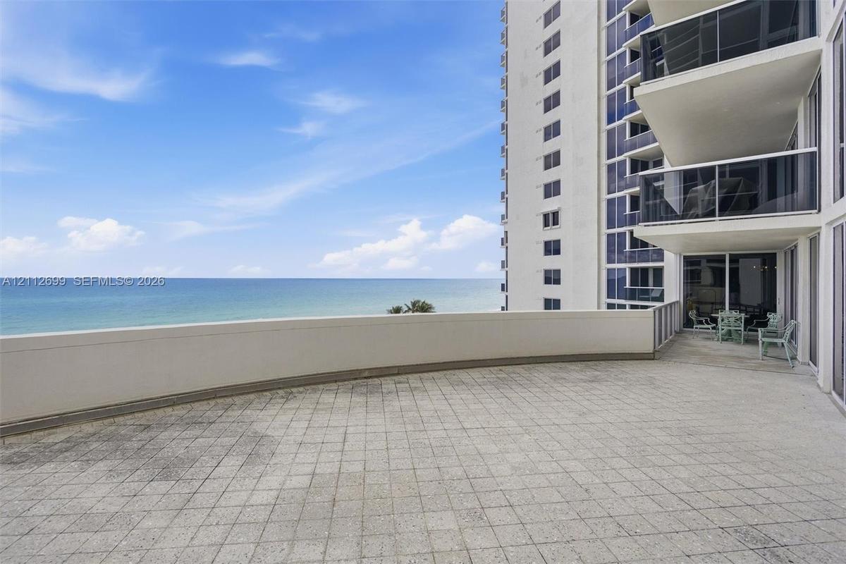 Expansive Oceanfront terrace featuring tiled flooring, a solid perimeter wall, and direct ocean exposure and breathtaking Sunrise views.