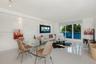 Open-concept living space featuring high-gloss tile flooring, floor-to-ceiling glass paneling, recessed lighting, and integrated track lighting