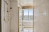 Stone-tiled shower connects two bathrooms in the primary bedroom.