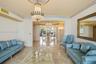 Polished stone flooring, ornate crystal chandelier, recessed ceiling medallion, decorative crown molding, and expansive floor-to-ceiling windows