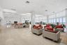 Expansive open-concept space featuring polished tile flooring, floor-to-ceiling windows, recessed lighting, and integrated circular light fixtures