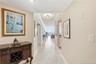 Spacious entry hallway with neutral tile flooring, crown molding, and a beautiful view straight through to the Atlantic Ocean.