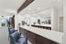 Stylish bar area with countertop seating, rich wood cabinetry, and a convenient location adjacent to the oceanfront social room.