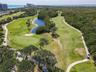 Enjoy the beautifully landscaped 9-hole golf course at Island Dunes Country Club, featuring lush fairways, scenic ponds, and a peaceful natural settin
