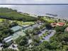 Aerial view of Island Dunes Country Club featuring tennis courts, pickleball courts, a golf course, and the scenic Indian River Lagoon.