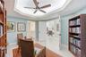 Another view of the library showcasing its custom wood built-ins, Murphy bed, and convenient access to the adjacent bathroom.