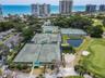 Aerial view highlighting the extensive tennis and pickleball facilities, golf course, and riverside clubhouse and marina.