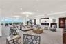 Beautifully furnished community social room featuring spacious seating areas, coastal décor, and expansive windows overlooking the Atlantic Ocean.