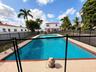 In-ground swimming pool featuring a tiled perimeter and metal safety fencing set within a concrete deck