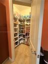 Walk-in pantry featuring built-in shelving and tile flooring