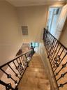 Staircase featuring stone-finish treads and ornate black metal balusters