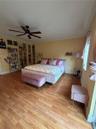 Wood-finish flooring, matte black ceiling fan, and crown molding
