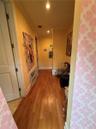 Hallway featuring wood-finish flooring, recessed ceiling lighting, and crown molding