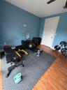 Interior room featuring wood-finish flooring, a solid-core paneled door, and a ceiling fan