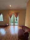 Wood-finish flooring, glass-paneled double doors, and private balcony with iron railing
