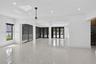 Large-format polished tile flooring, recessed ceiling lighting, structural support columns, black-framed sliding glass doors, and a decorative globe p