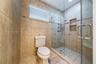 Walk-in shower featuring glass enclosure, built-in recessed shelving, wall-mounted shower head, and tile surround with integrated tile flooring