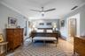 Neutral-toned bedroom featuring wood-finish flooring, crown molding, and a modern ceiling fan