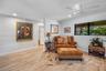 Light-toned wood-finish flooring, recessed lighting, white ceiling fan, and horizontal window with a black frame