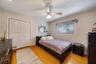 Room featuring wood-finish flooring, a ceiling fan with integrated lighting, and a white bifold closet door