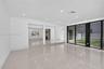 Polished tile flooring, recessed lighting, expansive sliding glass doors, and structural pillars featuring a raised elevation