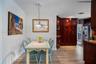 Custom floor-to-ceiling cabinetry with integrated wine storage, wood-finish flooring, and a multi-pendant glass light fixture